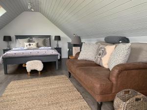 a living room with a couch and a bed at Wood Fired Hot Tub & Pergola with Glass Balcony. in Brecon