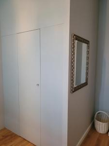 - Armario blanco en una habitación con espejo en Elegancki Apartament, en Puławy