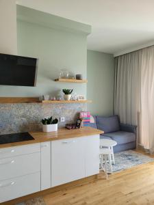 kuchnia z białymi szafkami i niebieską kanapą w obiekcie Elegancki Apartament w mieście Puławy