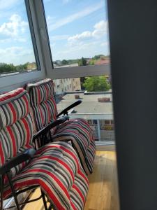 a row of chairs sitting in front of a window at Elegancki Apartament in Puławy