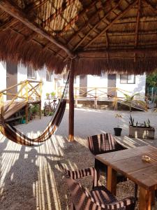 a patio area with a table, chairs, and umbrellas at EncantaLuna in Holbox Island