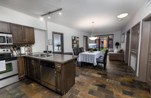 a kitchen with a table and a dining room at Upgraded lakeside resort dream vacation home in Kelowna