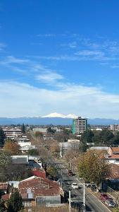 uitzicht op een stad met bergen op de achtergrond bij Departamento amoblado Chillán Centro in Chillán