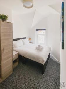 a bedroom with a bed with a dresser and a mirror at St. Michael's Apartments in Bournemouth