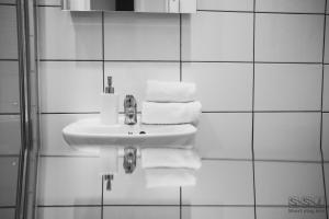 a white bathroom with a sink and towels at St. Michael's Apartments in Bournemouth