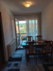 a dining room with a table and chairs and a window at Apartment EM 2 in Tuzla