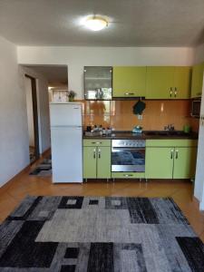 a kitchen with green cabinets and a white refrigerator at Apartment EM 2 in Tuzla