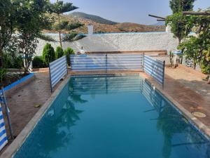una piscina con una valla azul alrededor en Dar ElBiad large family house en Ifargane
