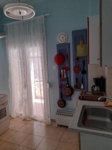 une cuisine avec un évier et une fenêtre dans l'établissement Sweet Home, à Thessalonique