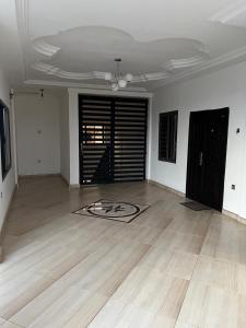 una sala de estar vacía con suelo de madera y techo en BAFFOUR APARTMENTS en Adiebaba