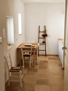una cucina con tavolo e sedie in una stanza di La Noscia - Le Dimore di Thesia a Otranto