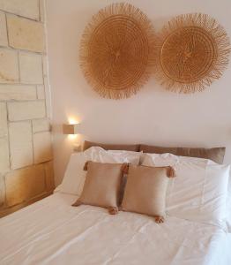 un letto bianco con due cuscini sopra di La Noscia - Le Dimore di Thesia a Otranto