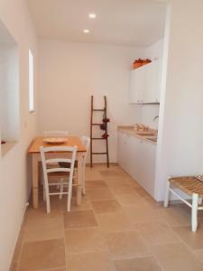 una cucina con tavolo, tavolo e sedie di La Noscia - Le Dimore di Thesia a Otranto