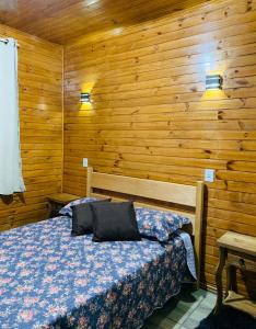 une chambre avec un lit dans un mur en bois dans l'établissement Meu Cantinho Serrano II, à Urubici 24 autres photos