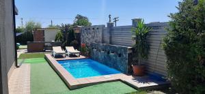 a small swimming pool with two chairs in a backyard at Portofino Villa in Costinesti
