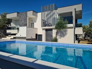a house with a swimming pool in front of it at Villa M&M in Sevid