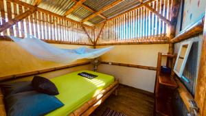A bed or beds in a room at The Mudhouse Hostel Mompiche
