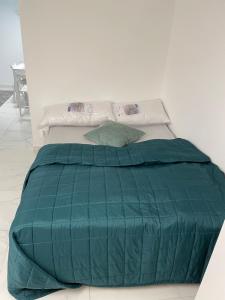 um edredão verde numa cama num quarto em Enna em Landskrona