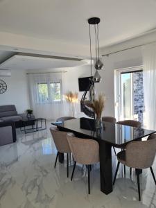 a dining room with a black table and chairs at Villa M&M in Sevid