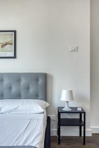 een slaapkamer met een bed en een bijzettafel met een lamp bij Appio Deluxe Apartment in Rome