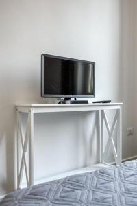 een flatscreen-tv zittend op de top van een witte tafel bij Appio Deluxe Apartment in Rome
