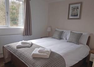 a bedroom with a white bed with towels on it at Llwyngwair Manor Holiday Park in Nevern