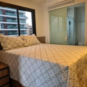 een slaapkamer met een groot bed en een raam bij Apartamento Smart Farol da Barra in Salvador