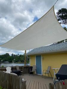 a large white canopy over a deck with chairs and tables at Cottage on Shalin Circle in Woodville