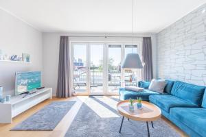 a living room with a blue couch and a table at Ankerzeit in Husum