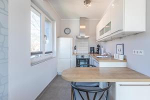 a kitchen with white cabinets and a wooden table at Ankerzeit in Husum