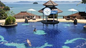 two people in a swimming pool at a resort at Supalai Scenic Bay Resort And Spa, SHA Extra Plus in Por Bay