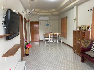a living room with a tv and a dining room at เพียงภูโฮมสเตย์ in Sattahip