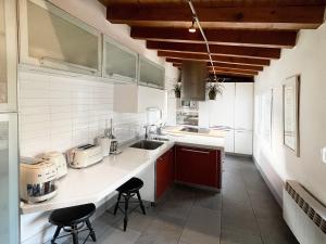 una cocina con armarios blancos y una barra con taburetes en Luxury Arquillos Vitoria, en Vitoria-Gasteiz
