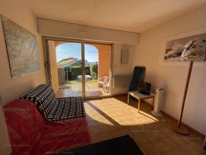 ein Wohnzimmer mit einer Couch und einer Glasschiebetür in der Unterkunft Rez-de-jardin T2 avec terrasse et parking - FR-1-100-284 in Rayol-Canadel-sur-Mer