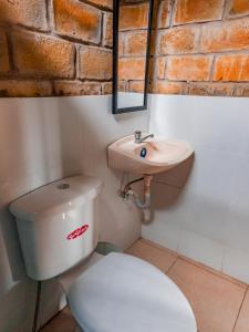 uma casa de banho com um WC e um lavatório em Hostal Tortuga Dorada em Puerto López