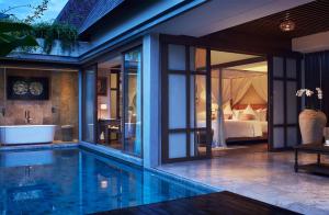 a villa with a swimming pool and a bedroom at Goya Boutique Resort in Ubud