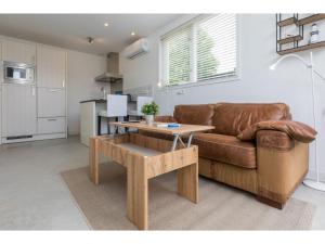BiggekerkeにあるHoliday Home in Biggekerke with Infrared Saunaのリビングルーム(ブラウンソファ、テーブル付)