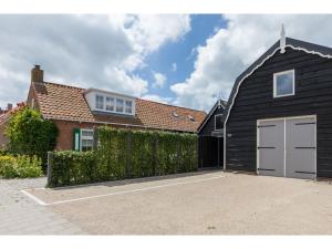 BiggekerkeにあるHoliday Home in Biggekerke with Infrared Saunaの私道の車庫付黒い家