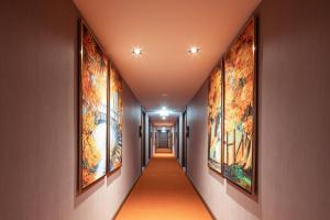 a hallway with paintings on the walls at The One Smart Living in Bangkok