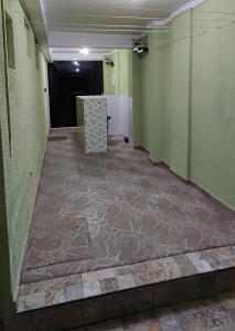 a hallway with green walls and a tile floor at Casa Privativa Metrô Penha in Sao Paulo