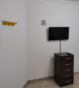a flat screen tv on a wall with a dresser at Casa Privativa Metrô Penha in Sao Paulo