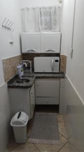 a small kitchen with a sink and a microwave at Casa Privativa Metrô Penha in Sao Paulo