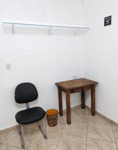 a chair and a table in a room at Casa Privativa Metrô Penha in Sao Paulo