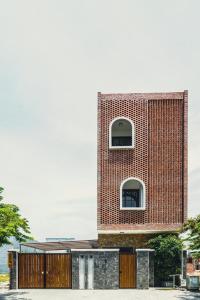 a brick building with two windows on top at Natsu No Hanabi Villa & Apartment in Da Nang