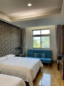 1 dormitorio con 2 camas y sofá azul en Lutai B&B, en Yung-an-ts'un