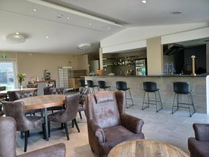 a restaurant with tables and chairs and a bar at Hotell Solstickan Mellbystrand in Mellbystrand