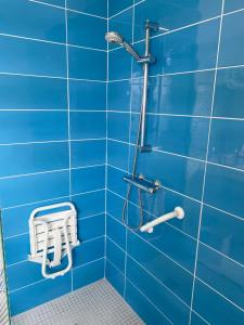a blue tiled bathroom with a shower with a white stool at maison Basque Maïana in Anglet +20 photos