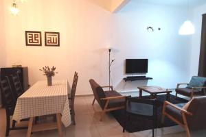 a living room with a table and chairs and a television at The Dandelion Homestay in Baling