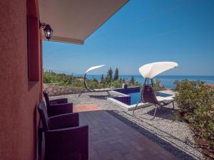 a patio with chairs and a view of the ocean at Harmonia Bungalows & Pool in Sveti Stefan