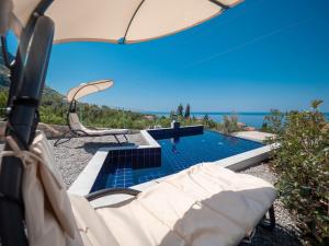 a view of a swimming pool with an umbrella at Harmonia Bungalows & Pool in Sveti Stefan